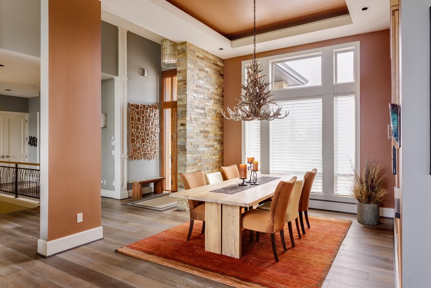 Rust themed dining area in a luxury home with lighting fixture and rug