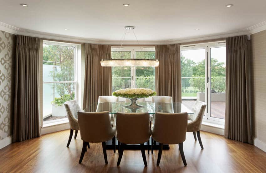 Dining room with hickory wood flooring bay window and curtains