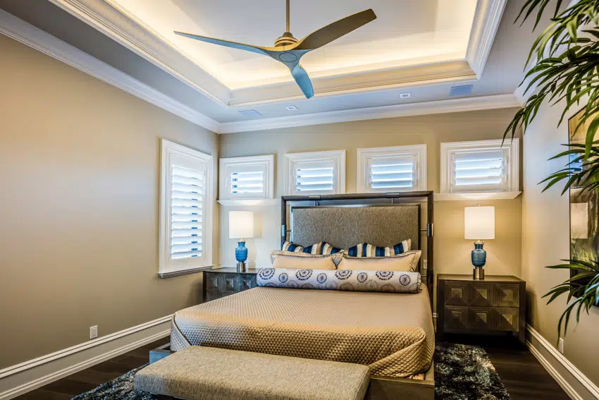 Gold painted bedroom with ceiling fan