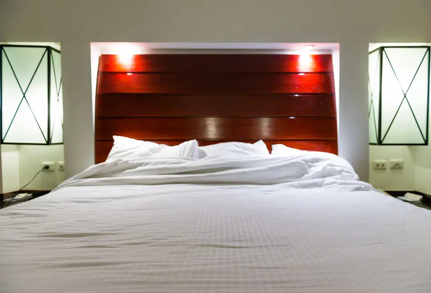 Hotel bedroom interior with striking read headboard and Egyptian bedding 