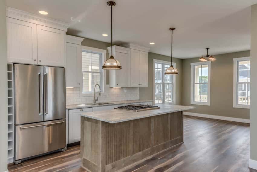 Kitchen area with pendant lighting refrigerator center island stove and wood floor