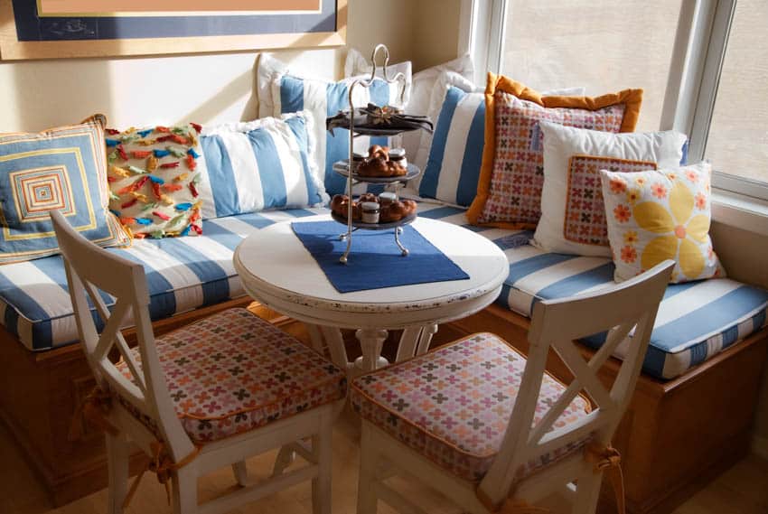 Kitchen booth with colorful pillows and small circular table