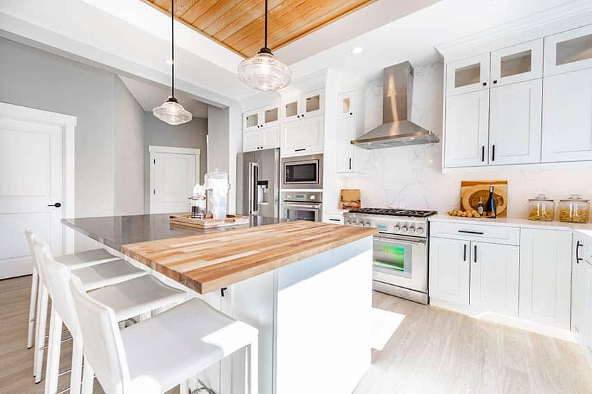 Kitchen with white cabinets light gray wall paint quartz backsplash butcher block island