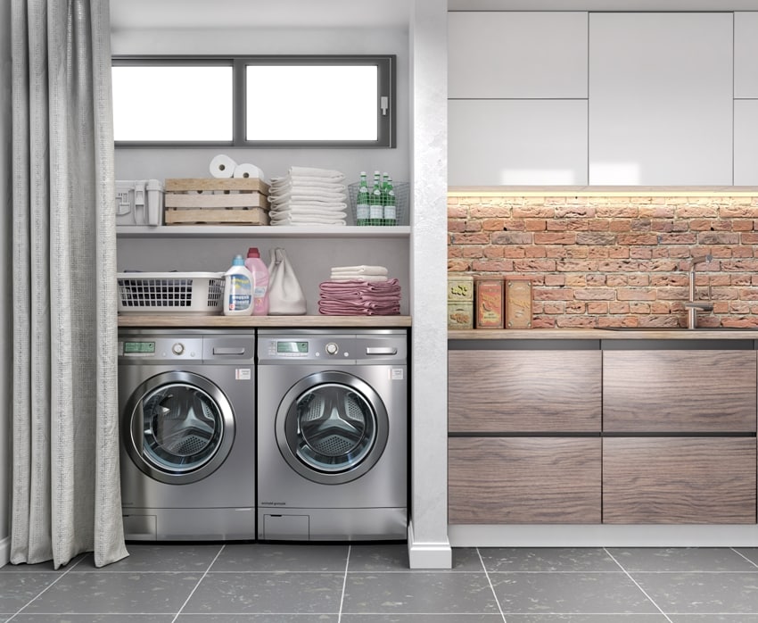 laundry with tile floor washing machine at closet grey wall shelving and fold clothes