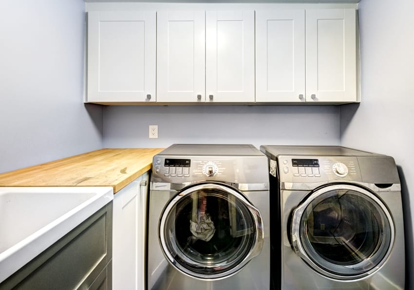 laundry room with washer dryer white cabinets and butcher block countertop
