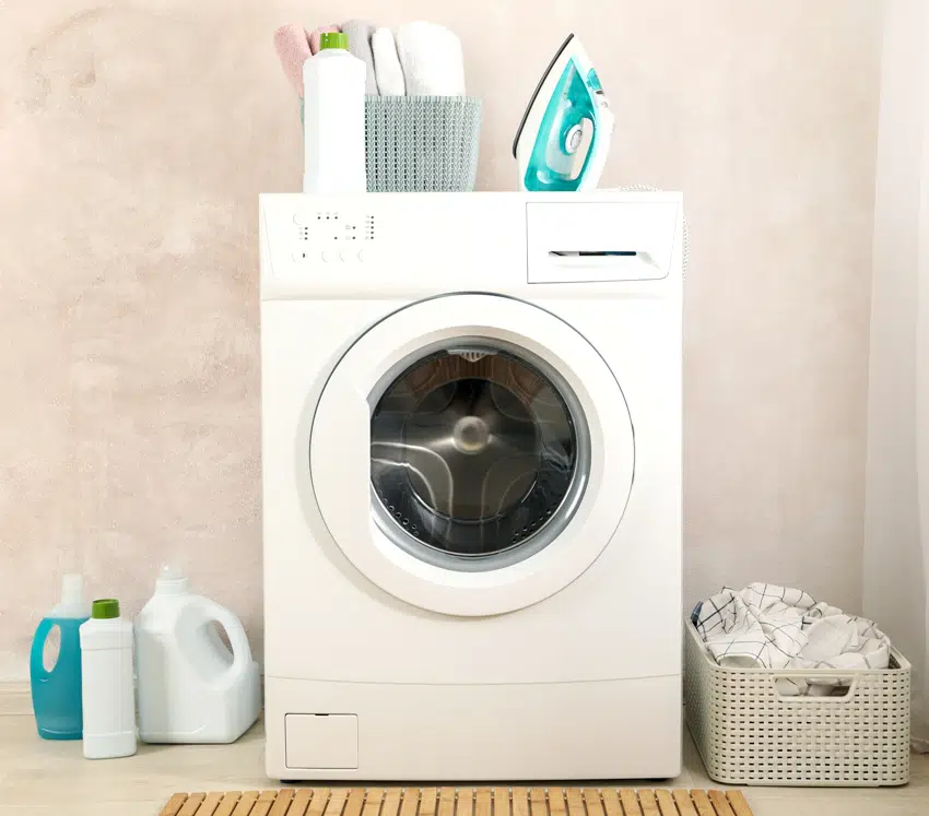 laundry room with washing machine hamper basket iron and detergents