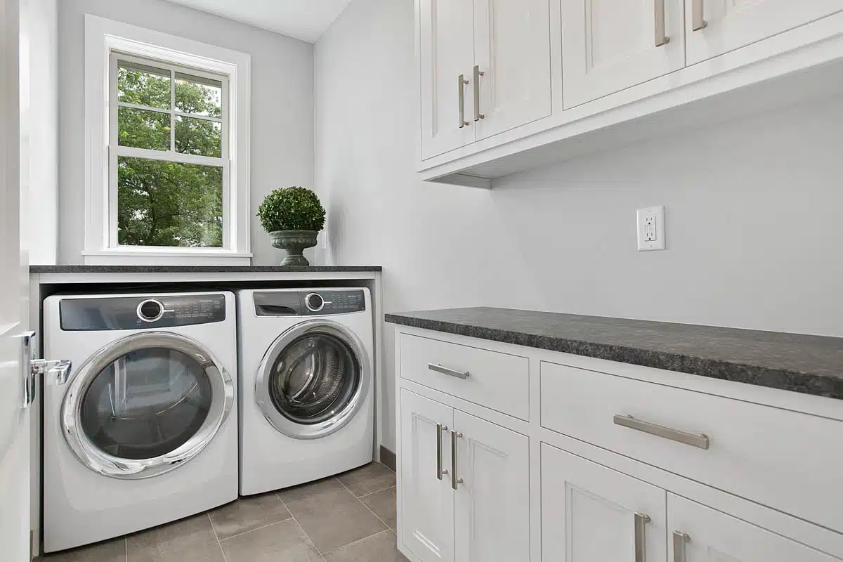 laundry space with granite countertop washing machines and cabinets