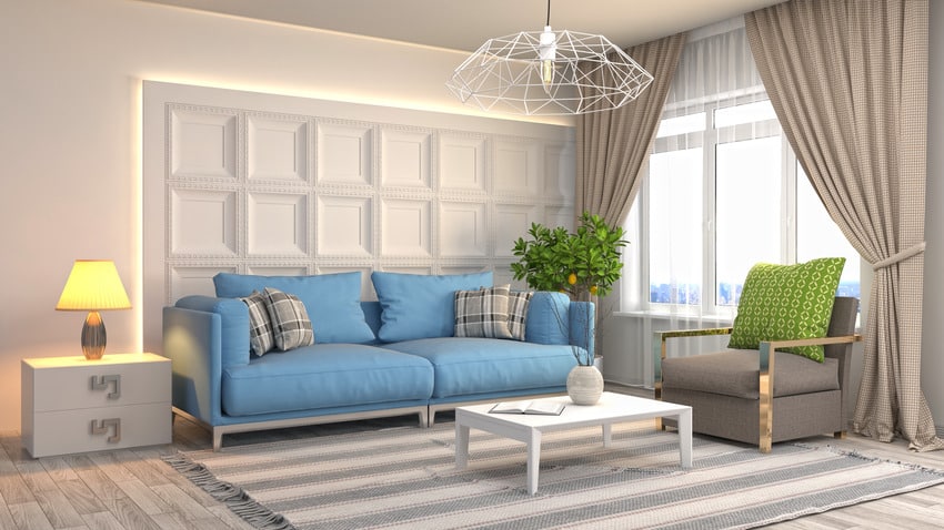 bright white accent wall blue sofa with geometric chandelier and horizontal prints on cotton rug