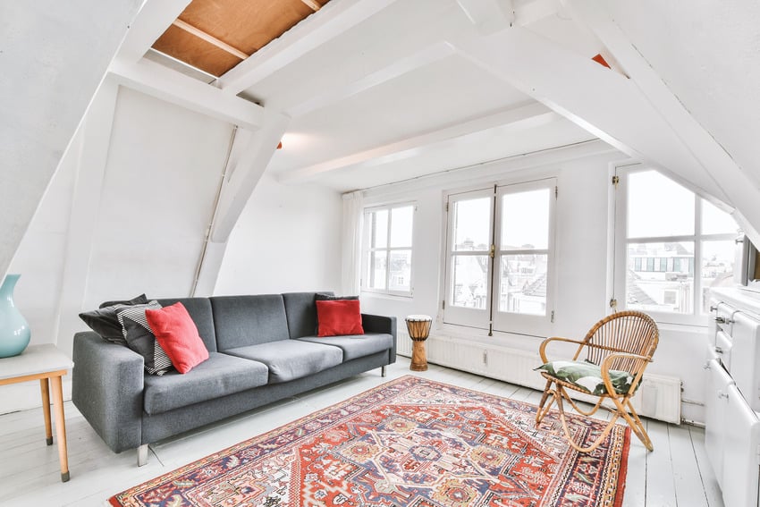 loft type living space with wicker armchair sofa and persian rug