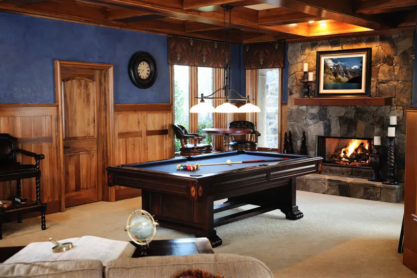 Man cave with color blue wall wood coffered ceiling fireplace and billiards table