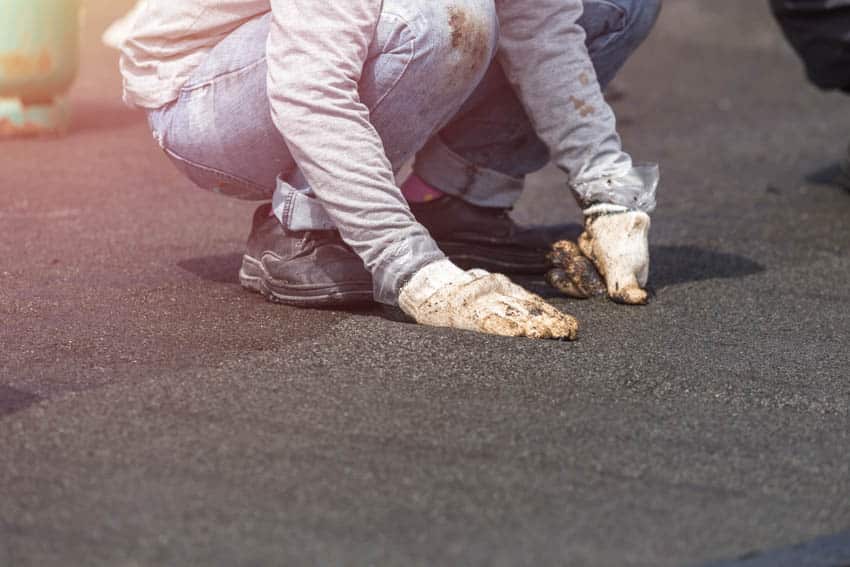 Man installing underlayment on flat roof