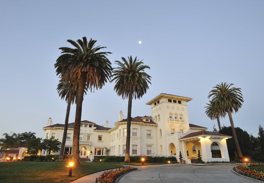 Mansion illuminated by solar driveway lights at dusk