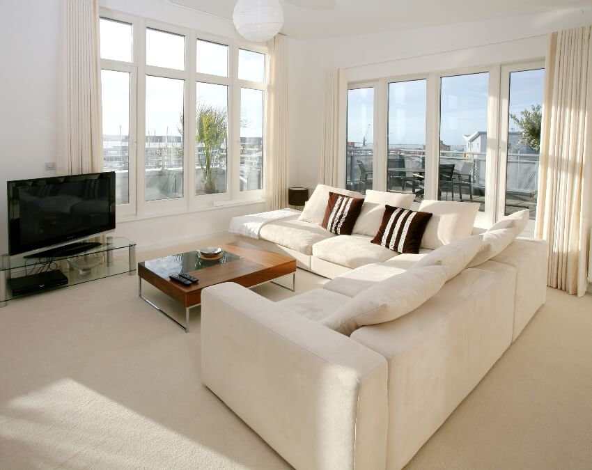 Modern apartment room with corner suite and flat screen tv