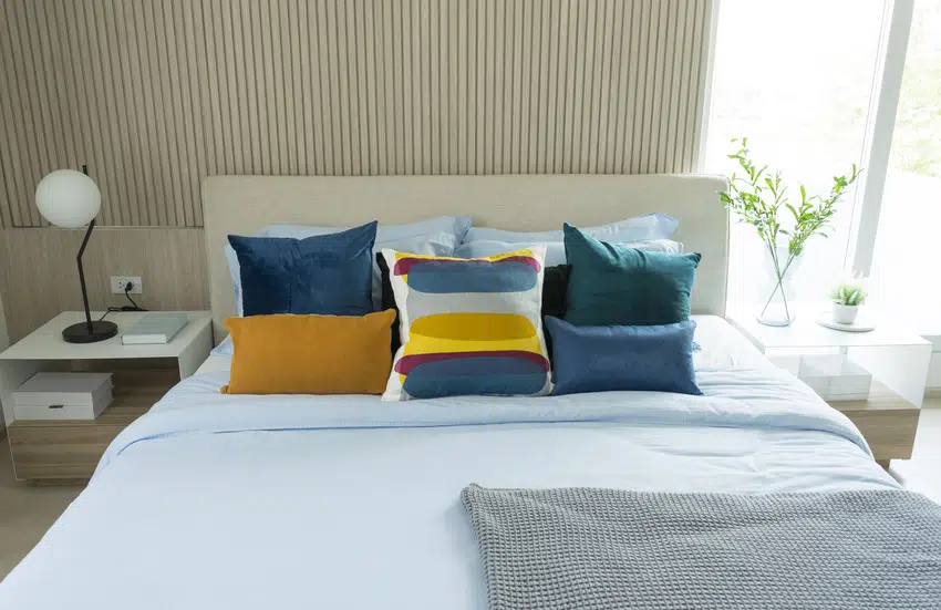 Modern bedroom interior with blue and yellow pillows 