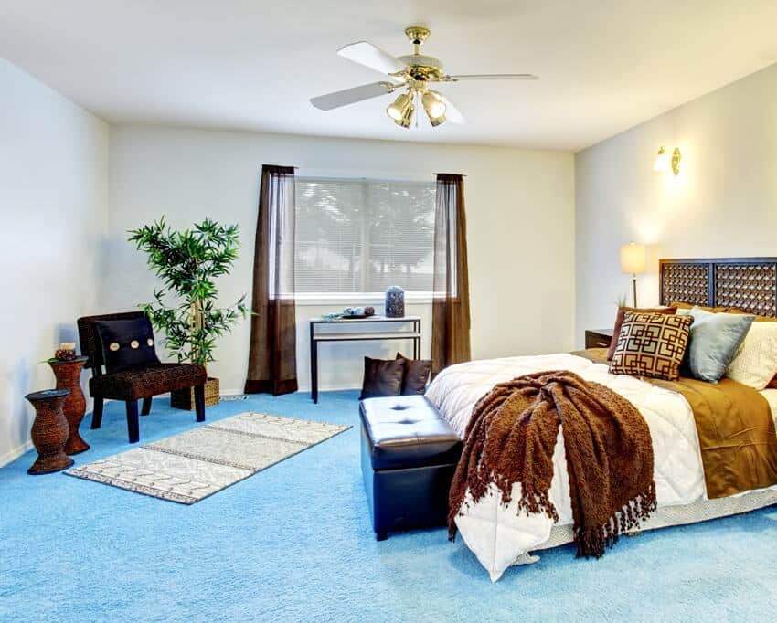 bedroom with blue carpet, wooden furniture and brown curtains