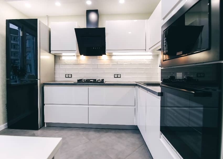 modern compact white kitchen interior with built in gas stove refrigerator oven