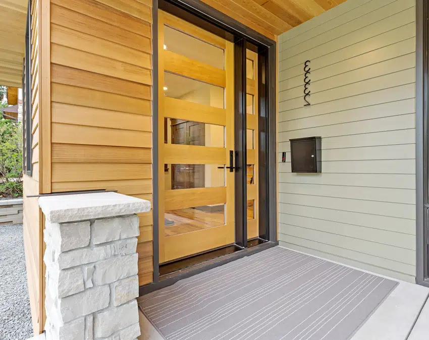 Home with glass paneled front door and composite siding