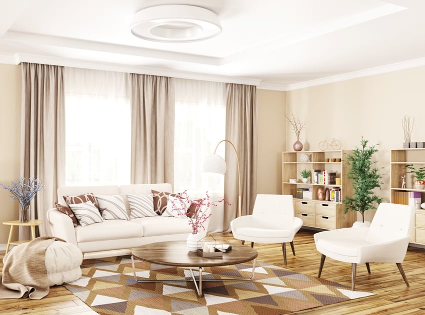 modern interior of living room with white sofa armchairs beige curtains and coffee table