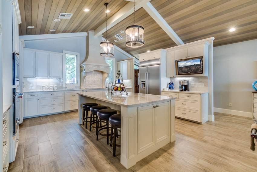 Modern kitchen interior with beige paint, wooden flooring and light fixtures