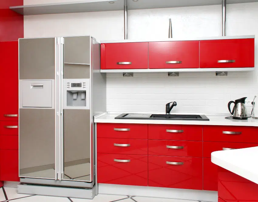 Modern kitchen with red cabinets white walls and gray fridge