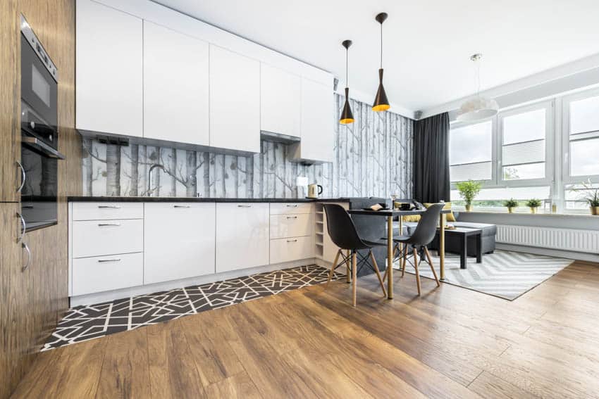 Modern kitchen with wallpaper backsplash white cabinets wood flooring chairs table