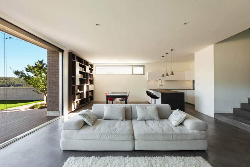 Modern living room with grind seal polished concrete floors and dining room and kitchen behind