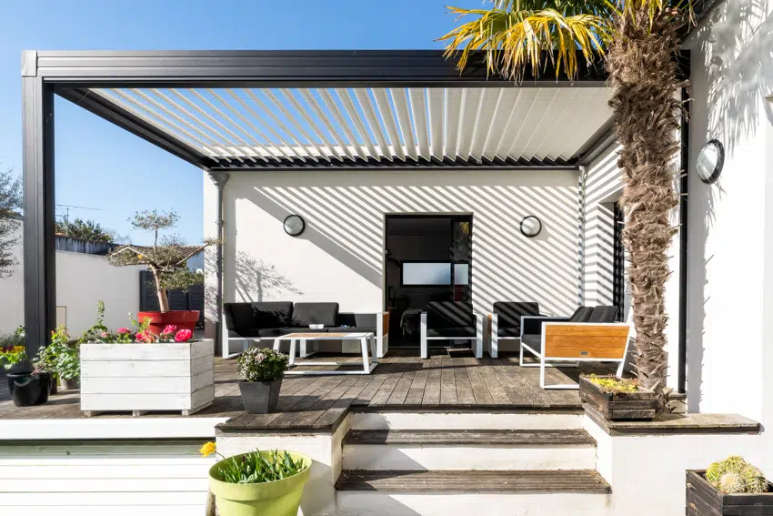 Modern pergola with louvered roof and furniture on wood patio