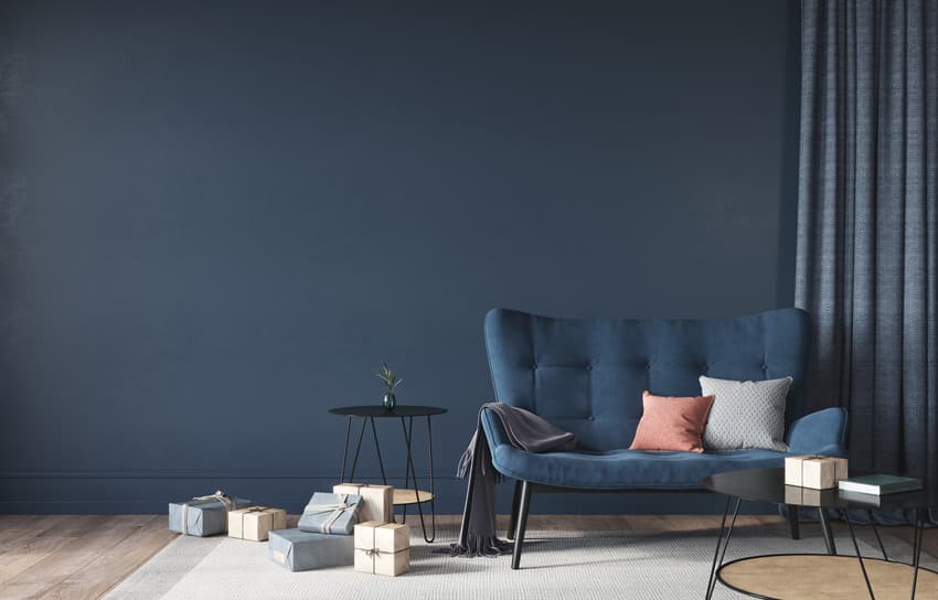 Navy blue living room interior with couch decorative pillows and curtain