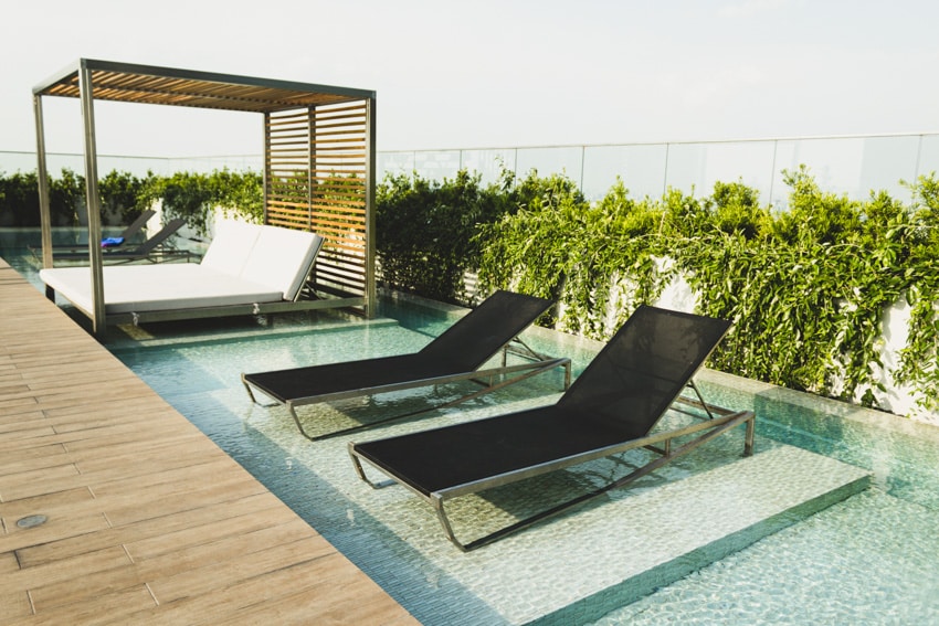Pool with loungers and bed on ledge