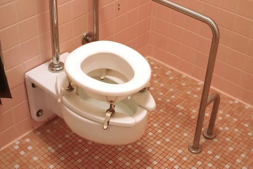 Raised toilet seat in coral bathroom interior