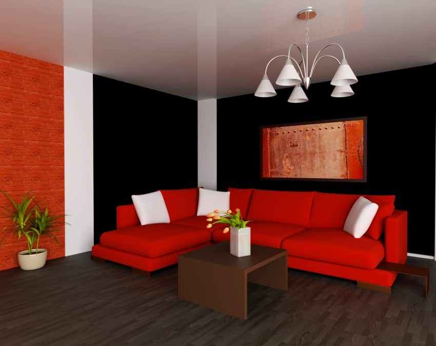 red sofa with white pillows black painted wall with heartthrob red white accent wall paint and wooden floor