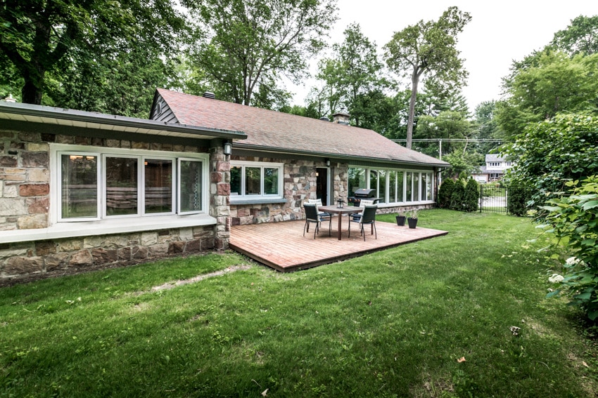 Small deck outside of house with furniture