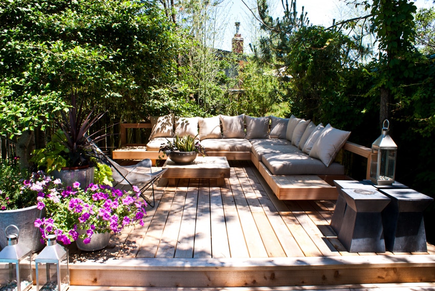 Small wood deck with sofa table flowers and trees