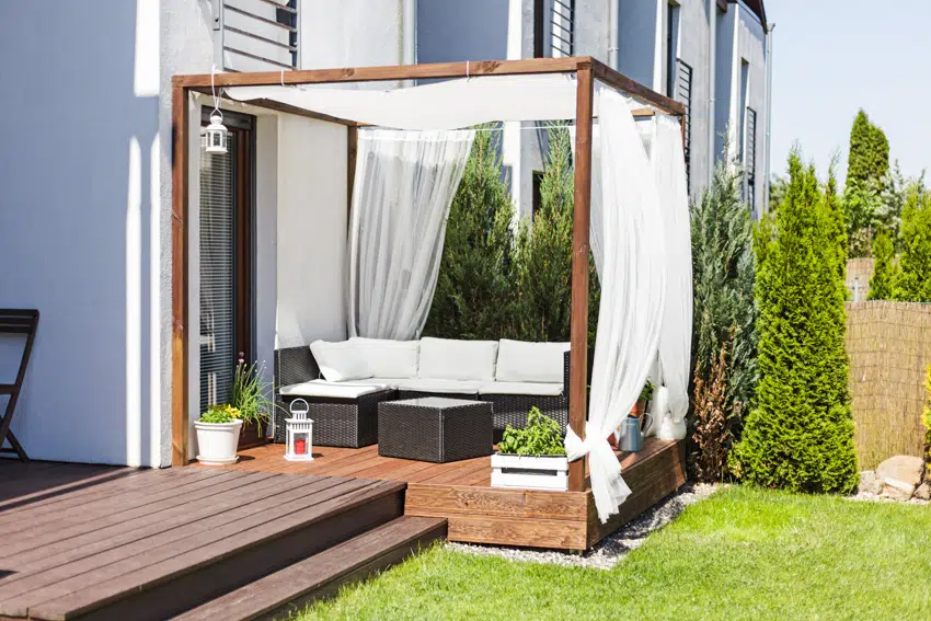 Small wood deck with white curtains