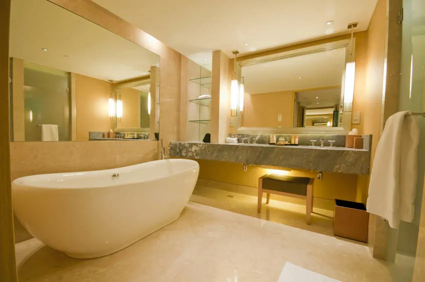 Spacious bathroom with tub concrete countertop mirror lights towel holder