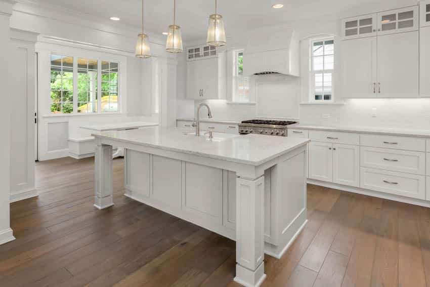 Spacious kitchen with white island and booth near windows