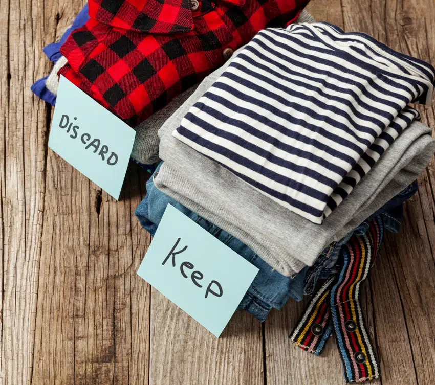 Stack of old clothes with discard or keep label