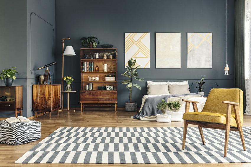 Stylish bedroom with yellow accent chair and striped rug