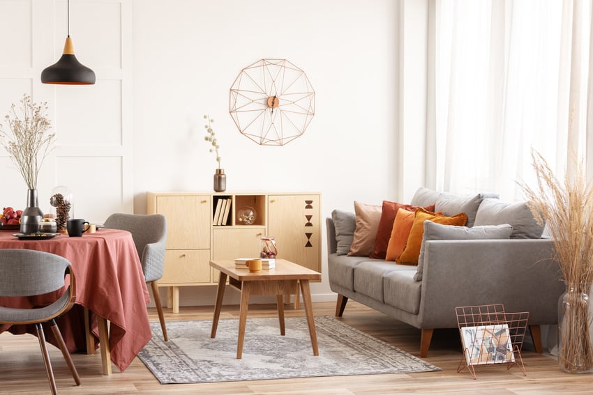 autumn themed dining-living area space with light fixture colorful pillows and distressed rug