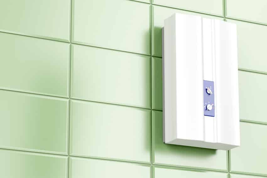 Tankless water heater on green tiled wall