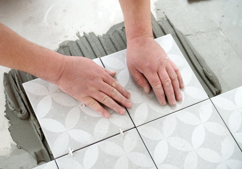 tiler laying the ceramic tile on the floor