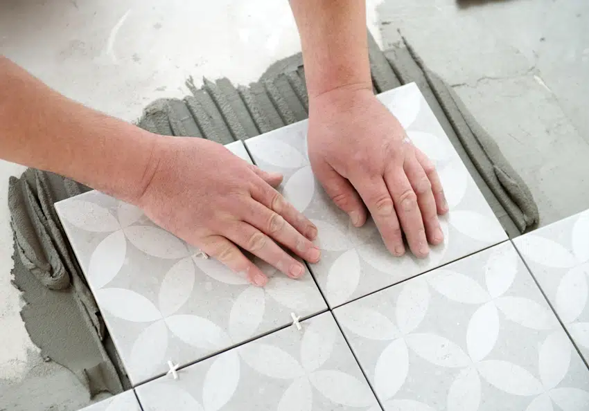 Tiler laying the ceramic tile on the floor
