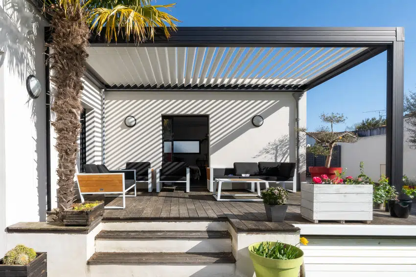 Trendy pergola with lounge chairs and metal grill 