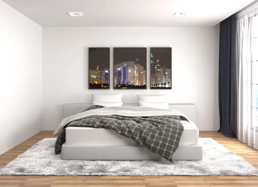 White bedroom interior with white carpet on the floor a bed and wall paint