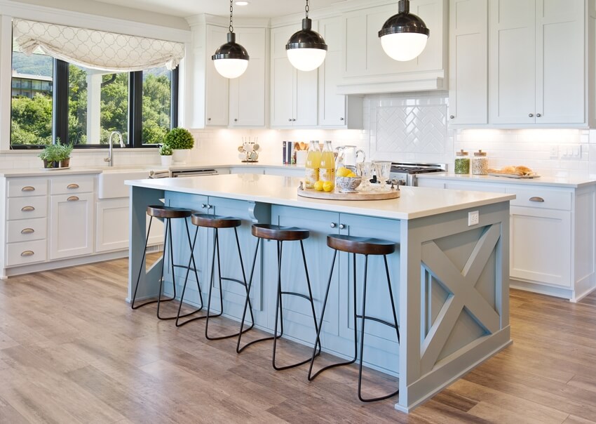 White gourmet kitchen with beautiful pendant lights and light blue kitchen island trim and brown chairs