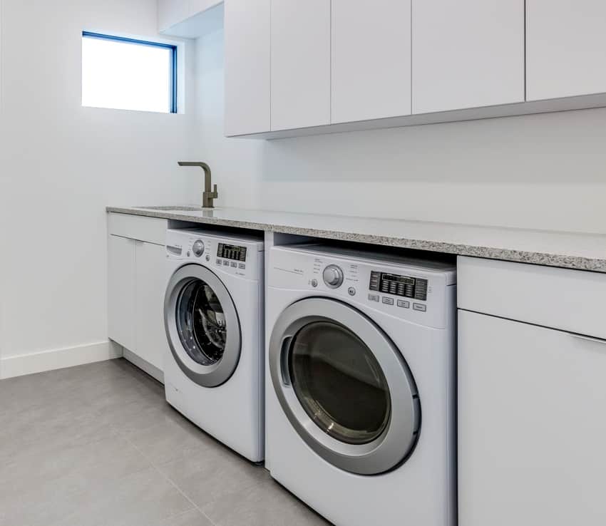 white laundry layout with solid surface countertops a washer and a dryer