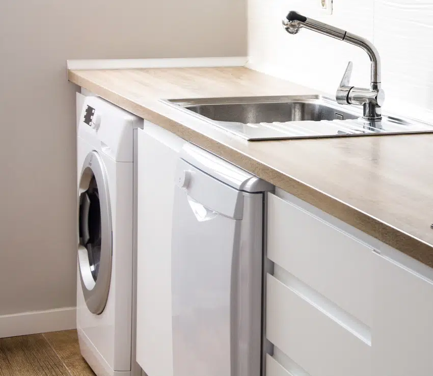 white modern laundry room with washing machine with laminate countertop 