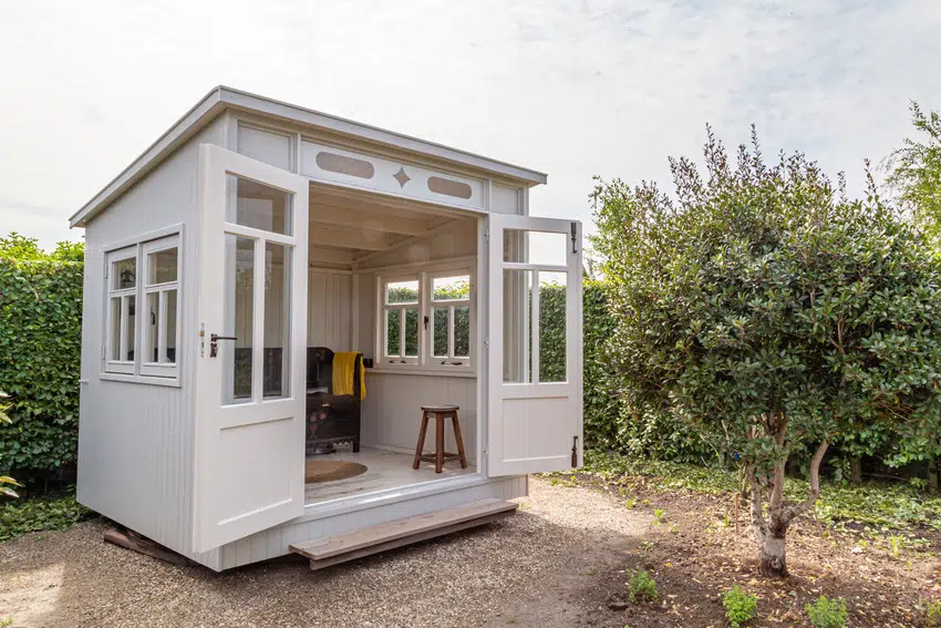 White shed doubling as sunroom in garden