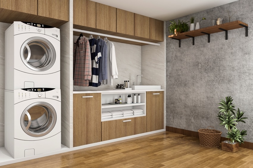 wood laminate floors laundry room with concrete wall 