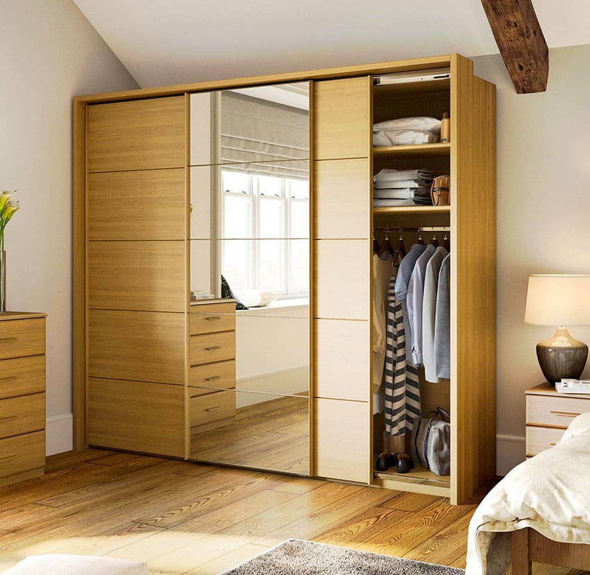 Wood wardrobe closet in bedroom with mirror, lamp, and wooden floors